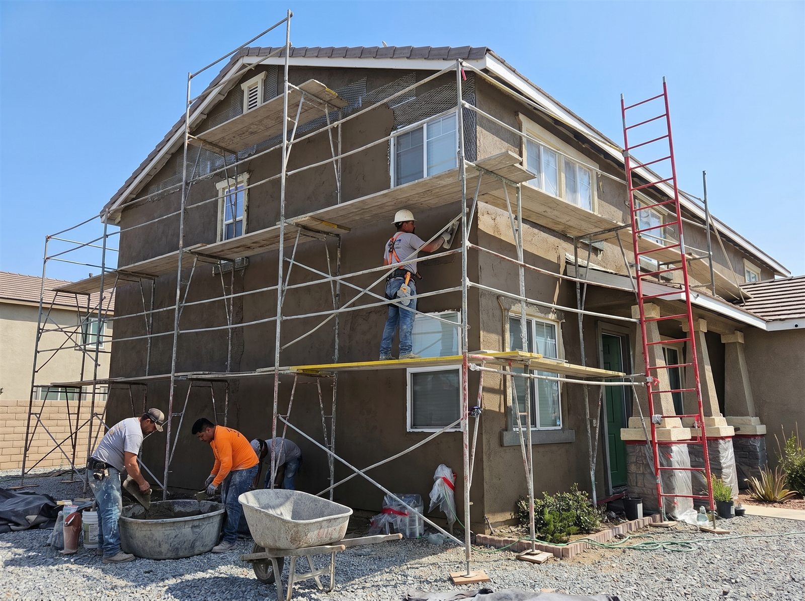 A1 crew applying the 3-coat stucco system on a two-story home