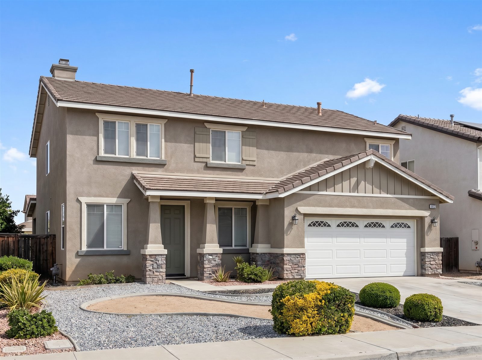 Completed tan stucco home with stone veneer accents